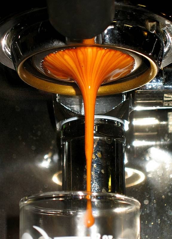Espresso qui coule d'un porte-filtre dans un verre.